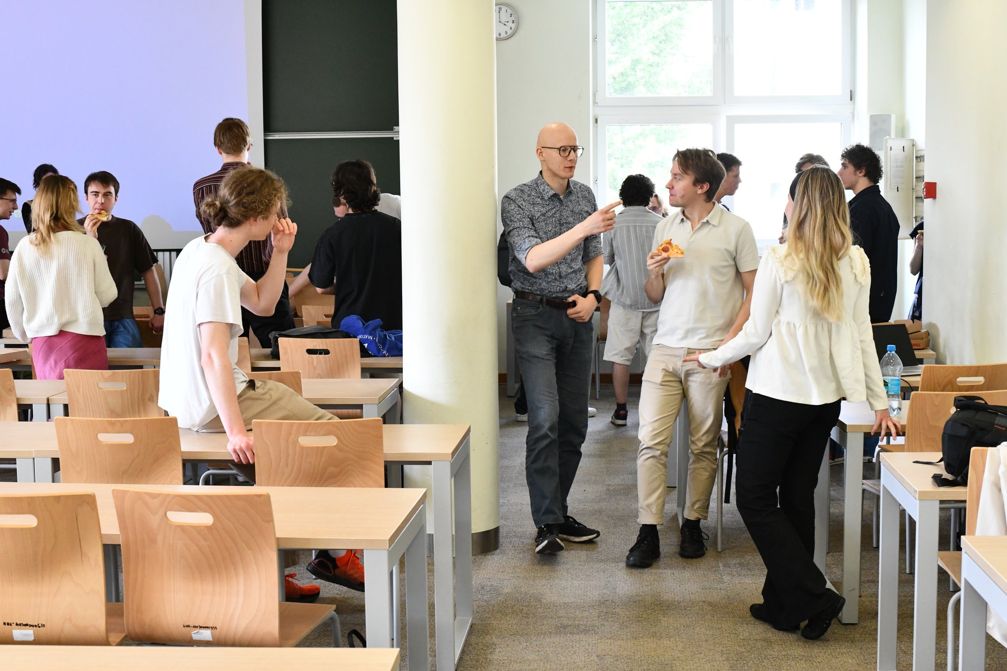 Attendees chatting over pizza after the talks